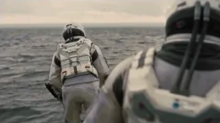 two astronauts with gun walking on ocean — Interstellar