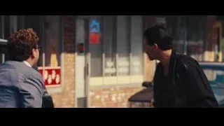 Two men conversing by a car on street — The Wolf Of Wall Street