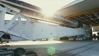 crane lifting large rocket into hangar — Elon Musk: Return to Space