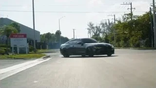 black sports car driving with blue smoke — Sports Cars