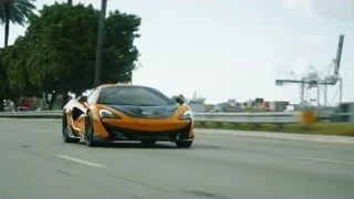 orange sports car driving on highway — Sports Cars