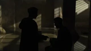 two men in concrete room talking — Blade Runner 2049