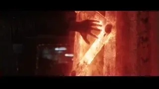 man holding gun in dark red lit room — Iron Man 3