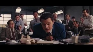 Man in blue suit talking to smiling men in office — The Wolf Of Wall Street