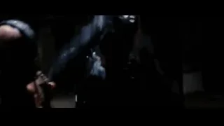 Masked man holding weapon in dimly lit room — Batman: The Dark Knight Rises