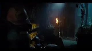 Man standing in dark cluttered room with fire — Jurassic World