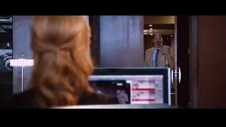 man in suit smiling by door, woman at desk — Iron Man