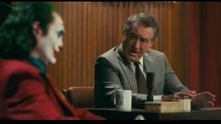 Joker in red suit with clown makeup gesturing — Joker