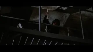 Person hanging from metal railing in dark — Bruce Lee: Enter The Dragon