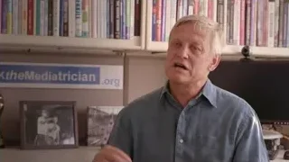 older man speaking in front of bookshelf — Screened Out