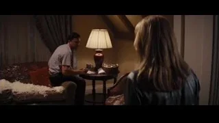 man deep in thought, woman standing in dimly lit room — The Wolf Of Wall Street