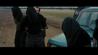 People in cloaks by blue car in field — Batman: The Dark Knight Rises