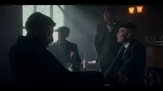men conversing at table in dimly lit bar — Peaky Blinders