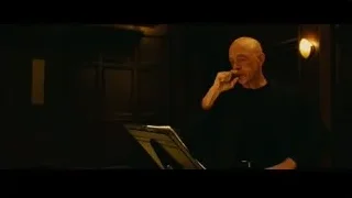 Elderly bald man with music stand in dimly lit room — Whiplash