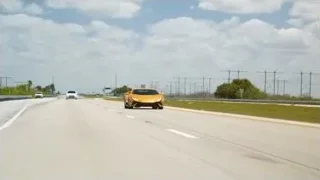 orange sports car driving fast on highway — Sports Cars