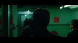 Man in suit standing in dimly lit green hallway — Whiplash