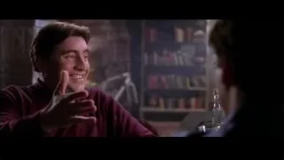 man laughing at table in dimly lit room — Spider Man 2
