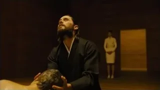 man massaging person's head in dark room — Blade Runner 2049
