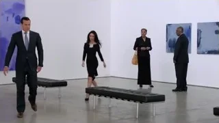 people walking in art gallery — Suits