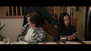 young couple at dining table with phone — The Social Dilemma