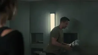 Man holding bag looking at woman in dimly lit room — Blade Runner 2049
