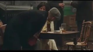 Two men at wooden table in dimly lit room — Peaky Blinders