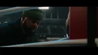 Two men conversing in dimly lit room — Creed 3