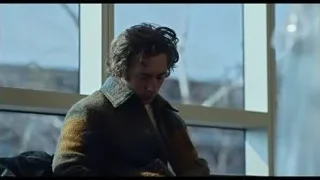 Young man sitting by window snowy landscape — The Bear