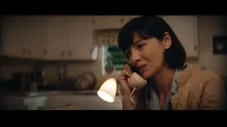 woman talking on phone in kitchen — Ford v Ferrari