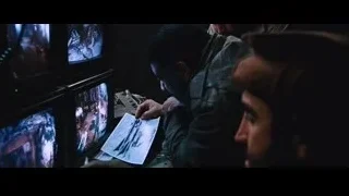 three men in uniform watching TV screens — Iron Man