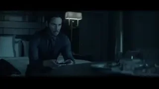 Man sitting on bed in hotel room — John Wick