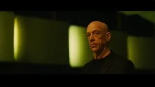 Bald man speaking on stage with green light — Whiplash