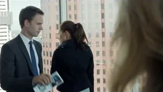 Man and woman conversing by city window — Suits