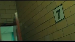 man looking out window in yellow jacket — Joker