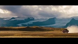 red bus driving through barren mountains — The Secret Life of Walter Mitty