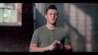 young man speaking in dimly lit brick room — The Social Dilemma