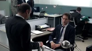 Man in suit sitting at office desk — Suits