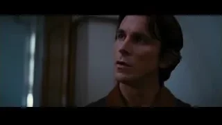 Man in brown jacket and scarf looking serious — Batman: The Dark Knight Rises