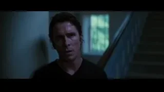man standing in dilapidated room with staircase — Batman: The Dark Knight Rises