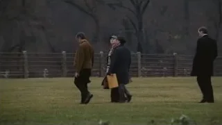 Four people walking in a grassy field — Succession