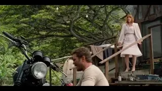 man and woman on wooden deck with motorcycle — Jurassic World