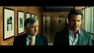 Two men in suits talking in hallway — Limitless