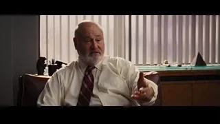 Elderly man in office chair looking at camera — The Wolf Of Wall Street