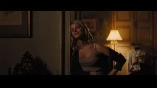 young woman leaning against wall in dimly lit room — Now You See Me