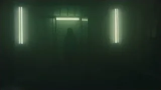 young woman standing in dimly lit room — Blade Runner 2049