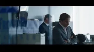 man in suit standing in office with monitors — The Big Short