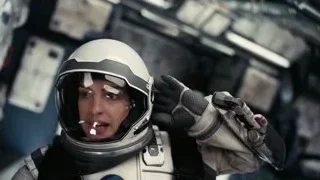 woman in spacesuit holding gun in control room — Interstellar