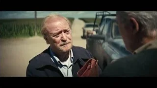 older man standing by car on dirt road — Interstellar
