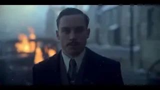 man in suit standing before burning building — Peaky Blinders