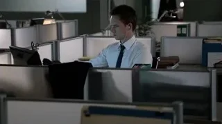 Man in office cubicle working at computer — Suits